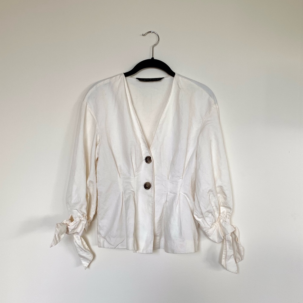 White button blouse with tied sleeves.